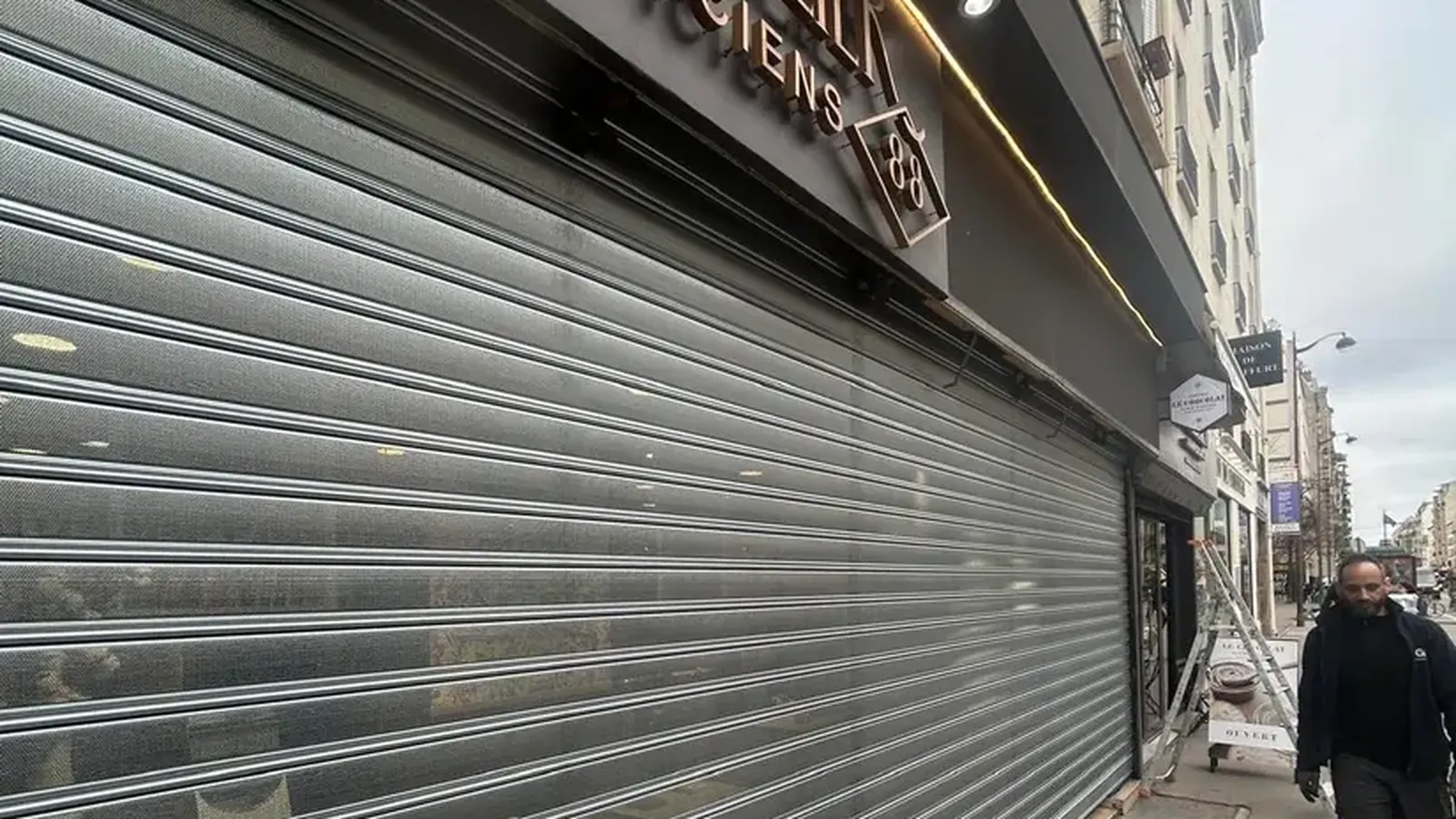 Artisan en intervention sur un rideau métallique, secteur Paris Ouest — Portech Fermeture